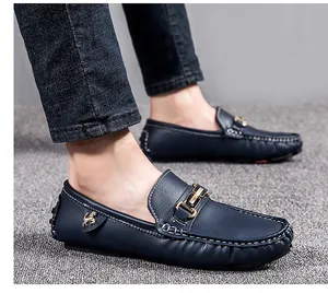 Detailed shot of navy blue men's loafers featuring gold horse ornament and white stitching