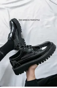 Nahaufnahme von schwarzen Lackleder-Brogues mit dicker Plateausohle