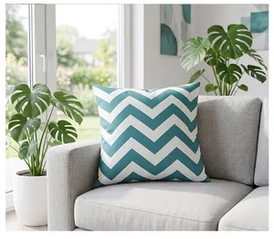 Close-up view of a teal and white chevron waterproof outdoor cushion cover on a grey sofa