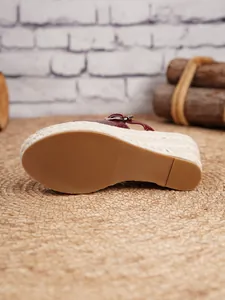Close-up of non-slip rubber sole on a women's straw braided wedge sandal