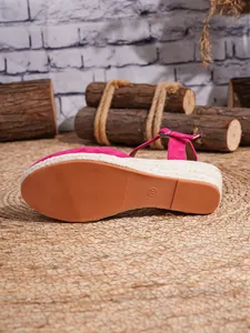 Vista inferior de las sandalias de cuña rosa con plataforma de alpargata trenzada