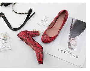 Detail view of red snakeskin pattern pumps with chunky block heels