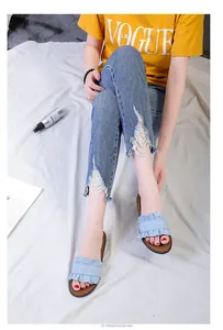 Women's light blue denim slides featuring stylish ruffle edge detail on a flat brown sole