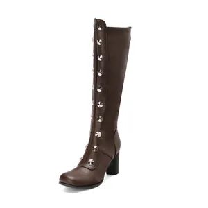 Side detail shot of brown knee-high boots featuring silver stud decorations