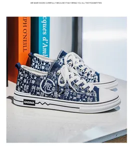 Primo piano di sneakers in tela blu con stampa di caratteri cinesi bianchi e lacci.