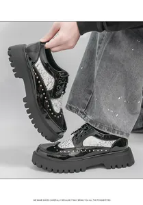Detailed view of men's black patent leather shoes with rivets and hand-painted patterns