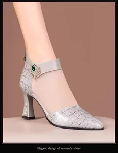 Detail of grey mesh high heel shoe featuring pointed toe and emerald jewel accent.