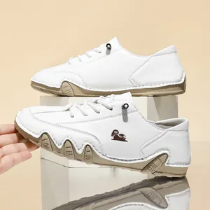 Detailed side view of white low-top casual shoes with distinctive brown octopus rubber sole.