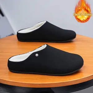 Zwarte met fleece gevoerde herenclogs met minimalistisch ontwerp op houten tafel