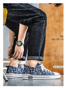 Primo piano di sneaker in tela blu con suola bianca e motivo a caratteri su un modello