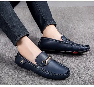Detailed shot of dark blue men's loafers featuring a golden buckle and horse emblem.