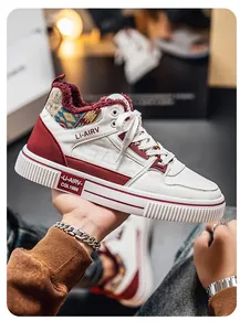 Dettaglio di sneaker in pelle bianca con calda fodera in pile rosso e motivo etnico.