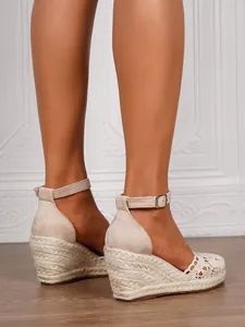 Detailed side view of beige women's crochet wedge espadrille sandals featuring ankle straps