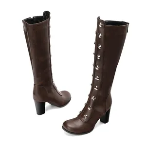 Detailed side view of brown knee-high boots featuring silver stud decorations and chunky heels.