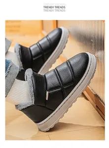 Detailed view of black slip-on winter boots with plush grey faux fur lining and sole