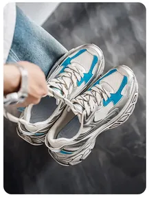 Close-up of stylish silver and blue men's chunky sneakers featuring breathable mesh and thick soles