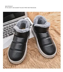 Close-up of black winter boots with grey faux fur lining on a plush rug.