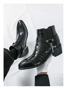Detailed macro view of men's black croc-embossed Chelsea boots with silver chain strap
