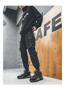 Stylized view of black men's leather chunky dad shoes with techwear cargo pants