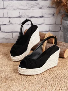 Detalle de sandalias de cuña negras con plataforma de cuerda de yute trenzada