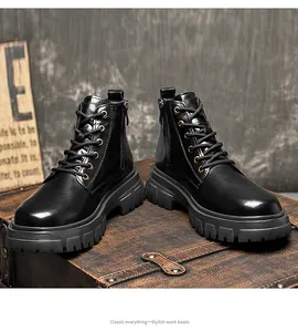 Detailed view of classic black leather work boots on a vintage leather trunk background.