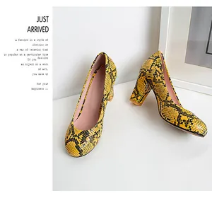 Detailed view of yellow snakeskin pattern on round toe chunky heel pumps.