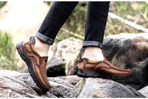Vista detallada de zapatos de cuero marrón transpirable para hombre en terreno rocoso