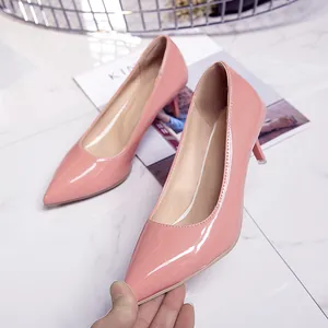 Close-up of elegant pink patent leather pointed-toe pumps with 6cm kitten heels.