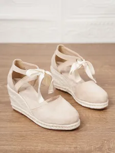 Vista detallada de alpargatas de cuña beige para mujer con lazo de cinta de seda