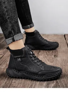 Vista lateral de botas Martin negras para hombre con cuero texturizado y suelas de tacos