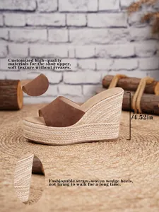 Detalle de sandalias de cuña de ante marrón con plataforma de paja y tacón de 11,5 cm
