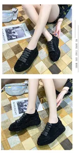 Detailed view of women's black rhinestone platform sneakers with sparkly embellishment