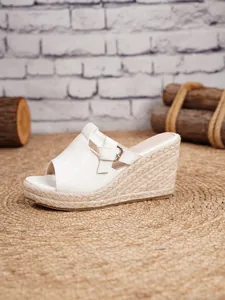 Side detail of white croc-textured wedge sandals with woven espadrille platform