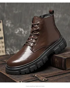 Classic brown leather high-top work boots with lug sole on vintage luggage