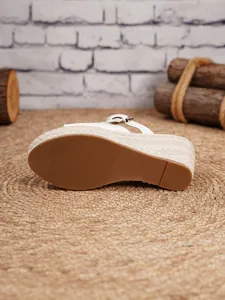 Detailed view of white wedge sandals featuring a braided jute platform and non-slip sole.