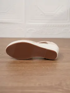 Detalle de la suela de goma duradera de las alpargatas de cuña de lona beige para mujer