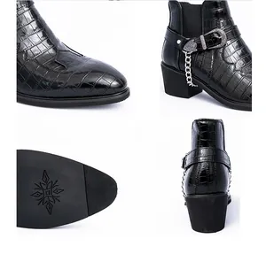 Close-up details of black crocodile pattern Chelsea boots with metallic buckle and chain.