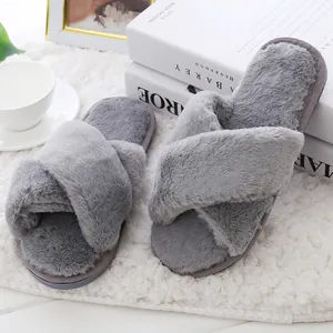 Detailed macro view of plush grey cross-band house slippers on a soft white rug