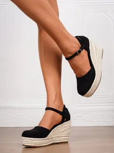 Detail der schwarzen geschlossenen Espadrille-Keilsandalen mit Plateau und Knöchelriemen.