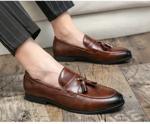Detalle de primer plano de mocasines de cuero marrón para hombre con borlas decorativas