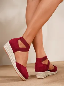 Detalle de sandalias de cuña color burdeos con suela de yute y tiras elásticas al tobillo