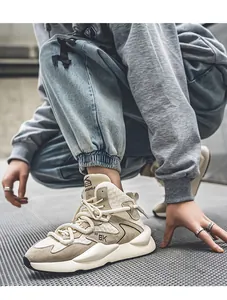 Detailed view of beige men's chunky sneakers in an urban street setting