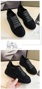 Detail view of women's black rhinestone platform sneakers with sparkling texture.