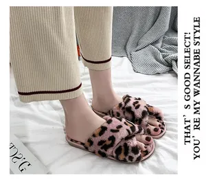 Close-up of stylish pink leopard print faux fur cross-strap slippers on model's feet