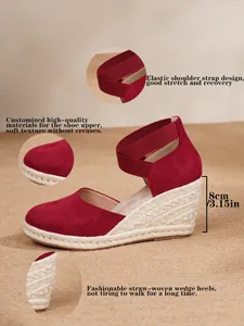 Detalle de sandalias con cuña de ante rojo, tacón de paja de 8 cm y correa elástica