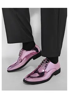 Close-up macro view of metallic pink pointed toe dress shoes with high-gloss finish