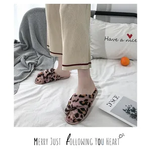 Close-up of leopard print faux fur cross-strap slippers in a cozy bedroom setting