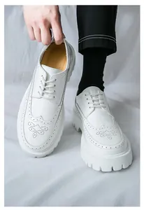 Nahaufnahme der weißen Plateau-Brogue-Schuhe mit Zierlochung und dicken Sohlen