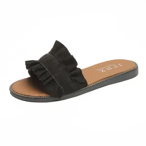 Detailed side view of women's black ruffled slide sandal featuring a brown beaded footbed