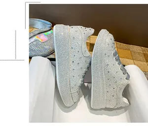 Detailed view of women's platform sneakers fully covered in shimmering silver rhinestones
